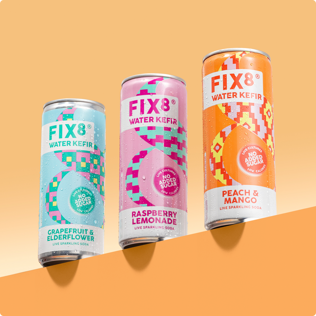 Three Fix8 Water Kefir cans on an orange backdrop